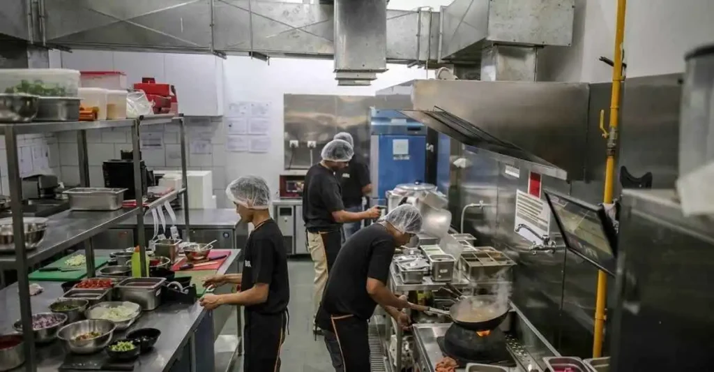 भारतीय क्लाउड किचन में शेफ ऑनलाइन फूड ऑर्डर तैयार करते हुए